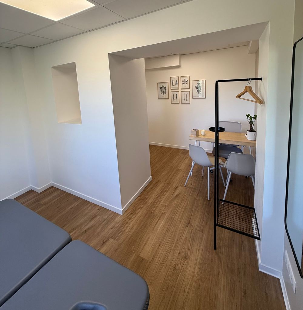 Vue du cabinet depuis la salle de soin, planches d'anatomie au mur